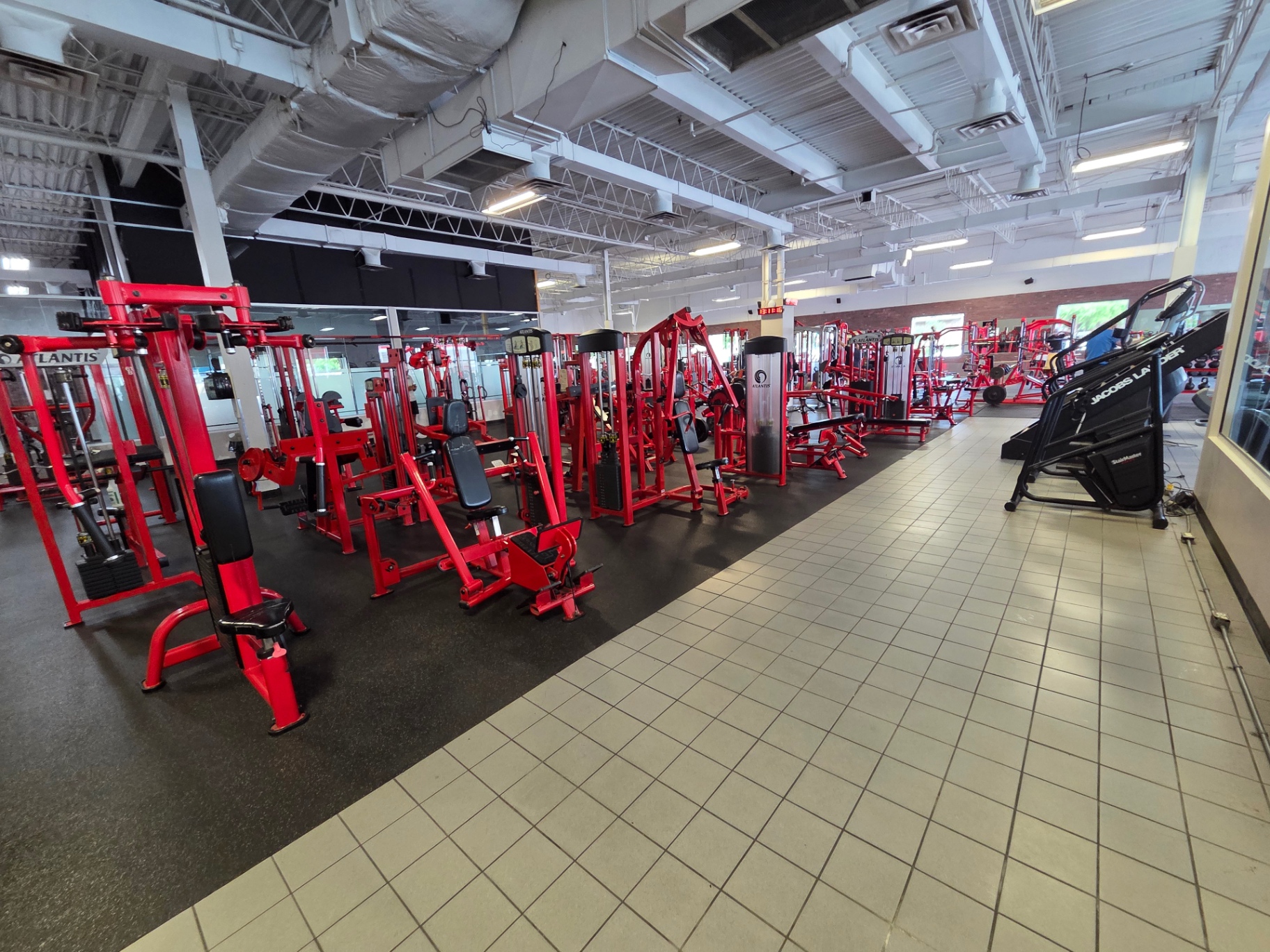 Membre s'entraînant seul sur le plateau chez Le Club Fitness à LaSalle, Montréal, dans une lumière industrielle chaleureuse